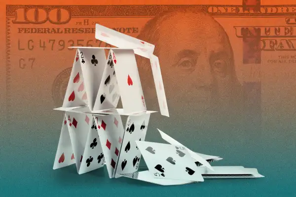 Photo collage of a falling house of cards with a hundred dollar bill in the background