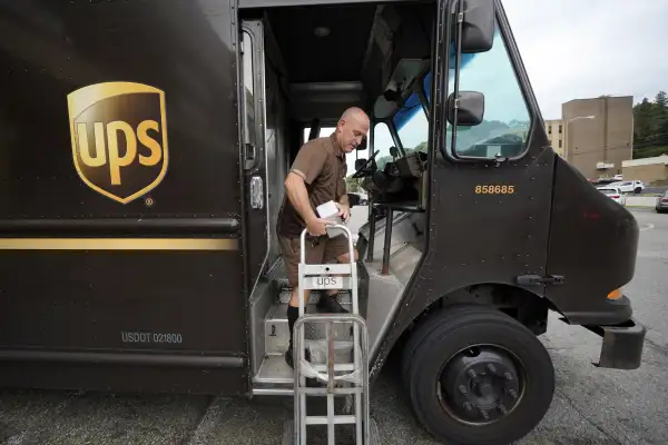 UPS delivery worker descending a UPS truck