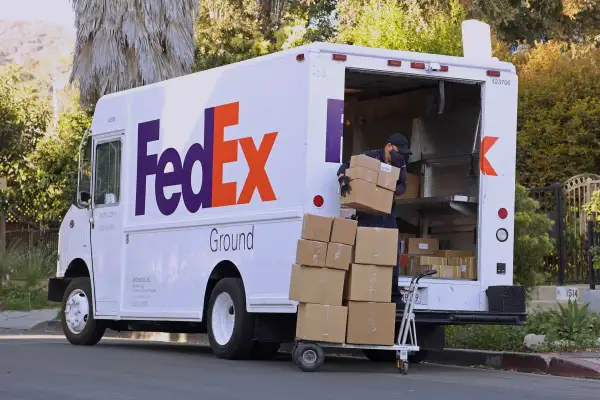 FedEx worker filling up a truck to deliver shipping packages