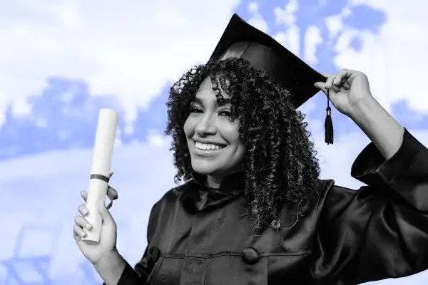 Young college graduate holding diploma, wearing a cap and gown