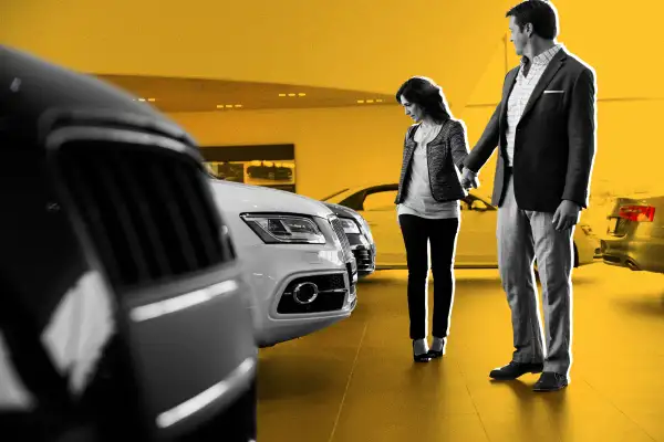 Couple looking at new cars at a car dealership