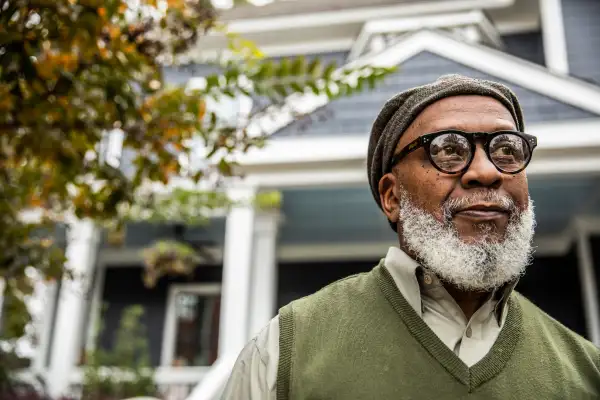 Senior man in front of suburban home