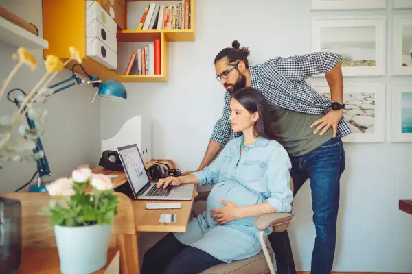 Pregnant Mother and husband working from homeAt home