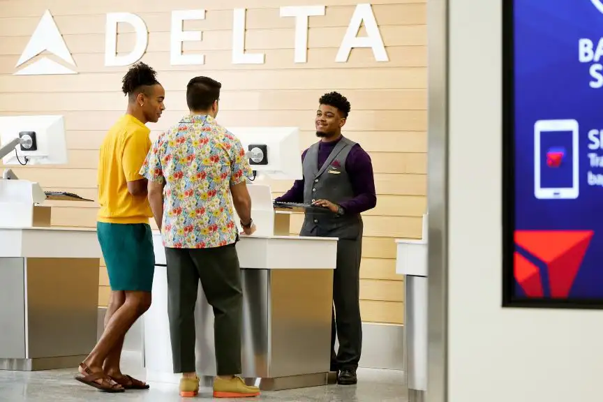 Two customers at a Delta counter at the airport