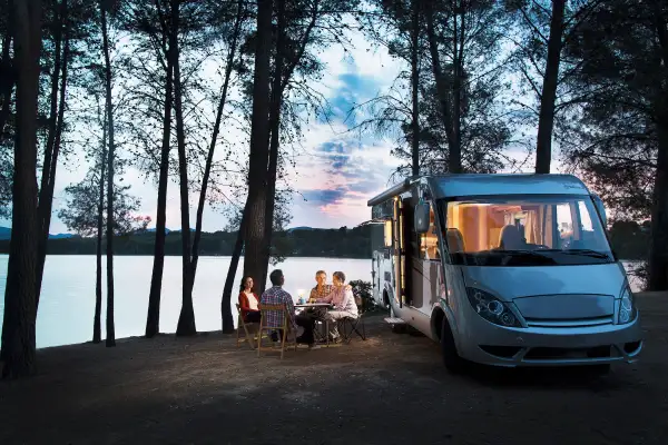 Friends sitting outside motorhome in the evening