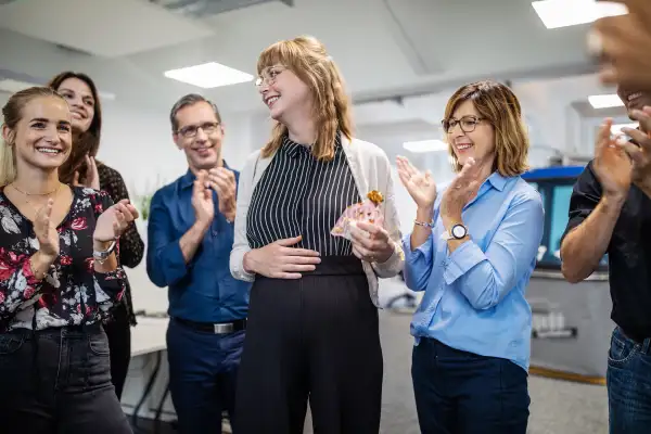 Business people applauding for pregnant colleague