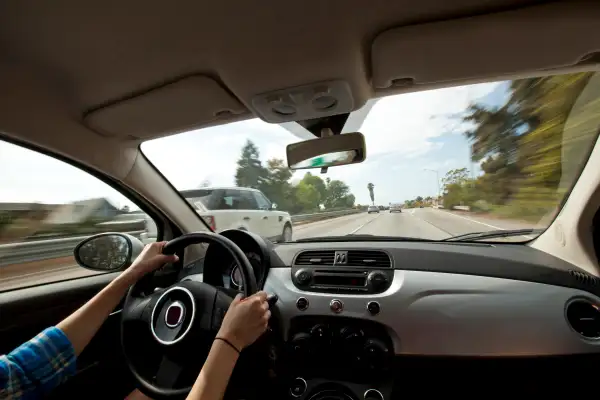 A female driving on a highway.