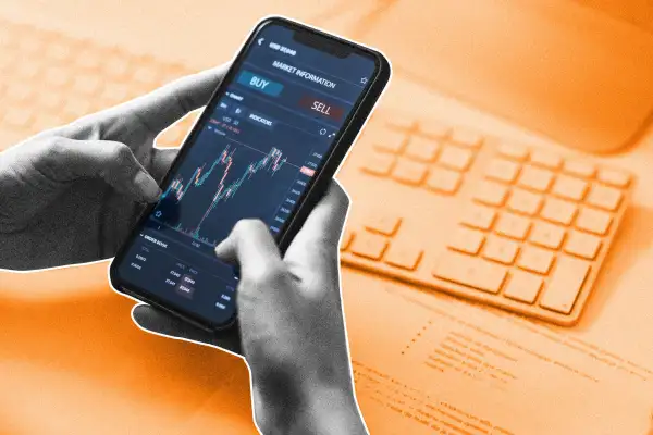 Close-up Shot of a Persons Hands Holding a Smartphone with a Stock Market Graph on Screen