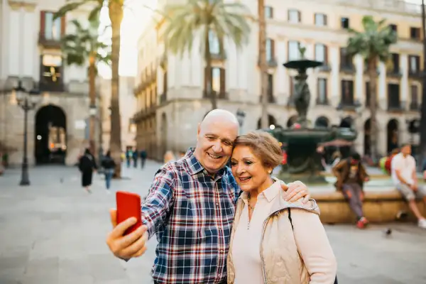 Older couple taking a selfie with their phone while on vacation