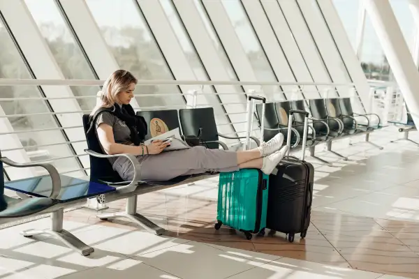 Woman waiting at the airport with her carry-on bag