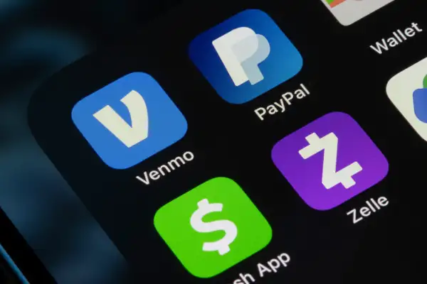 Close-up of a smartphone with payment apps on the screen (Venmo logo, PayPal, Zelle, Cash App)