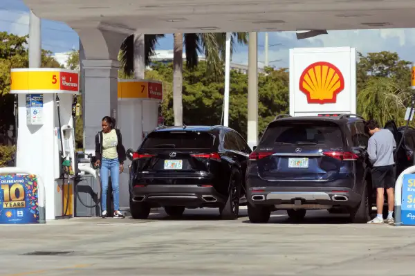 People fueling their cars at a gas station