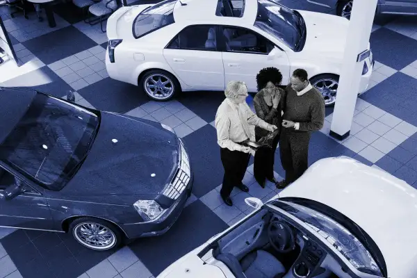 picture of a couple buying a car from a dealership