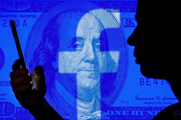 Photo illustration of a person using Facebook and a $100 dollar bill superimposed