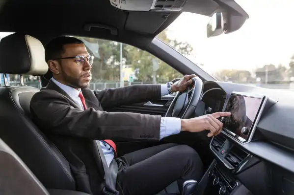 Side view of a businessman putting direction of his work in gps of his car