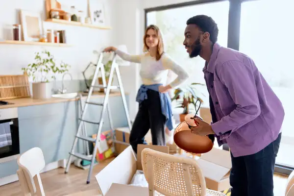 Man and woman packing personal belongings into moving boxes