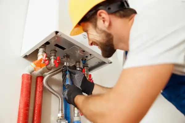 Closeup of plumber using screwdriver while installing water heater