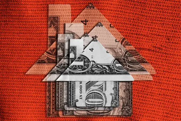 Photo Collage of multiple dollar bills folded up to look like a small house, stacked on top of each other in decreasing sizes