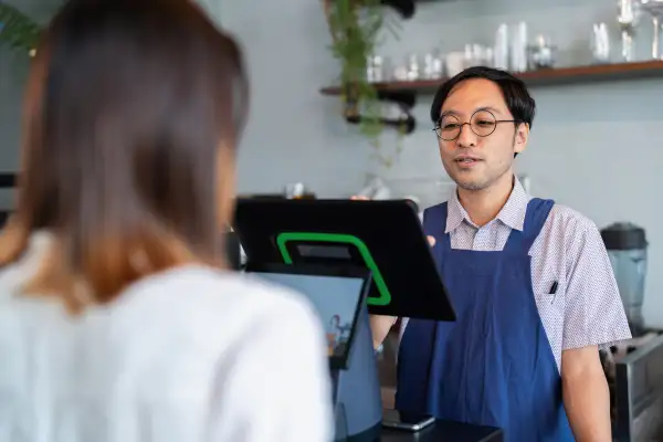 Person at a counter paying using a POS system