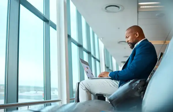 Man using a laptop at an airport