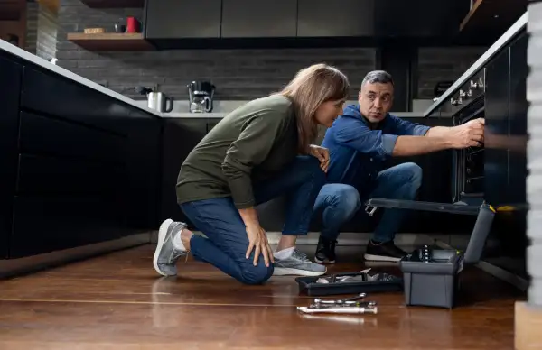 Electrician talking to a customer while fixing her over at home