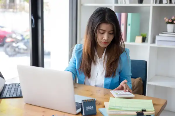 Business woman using a calculator to calculate taxes