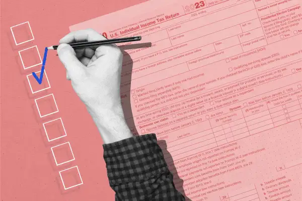 Hand filling out checkmark with an oversized 1040 tax form next to it