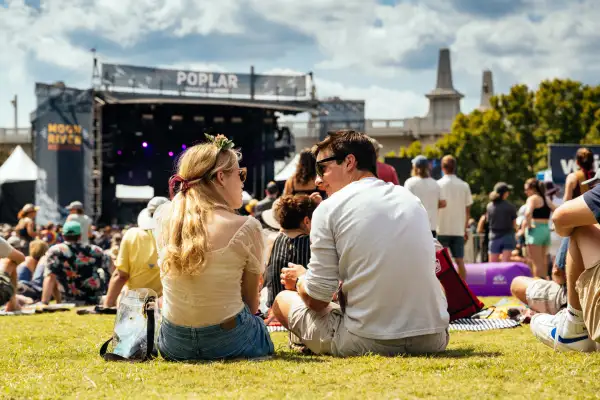 Two people sitting on the lawn at a music festival in Chattanooga