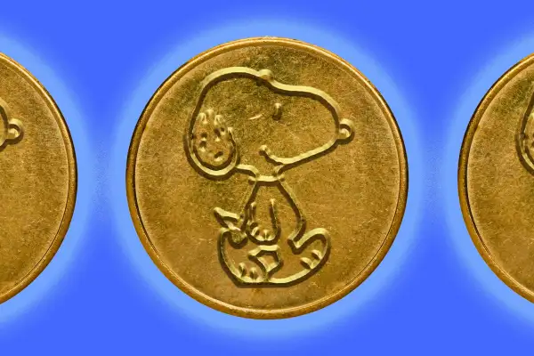 A gold coin with Snoopy embossed on it