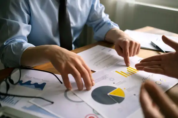 Close-up of two pairs of hands looking at credit reports