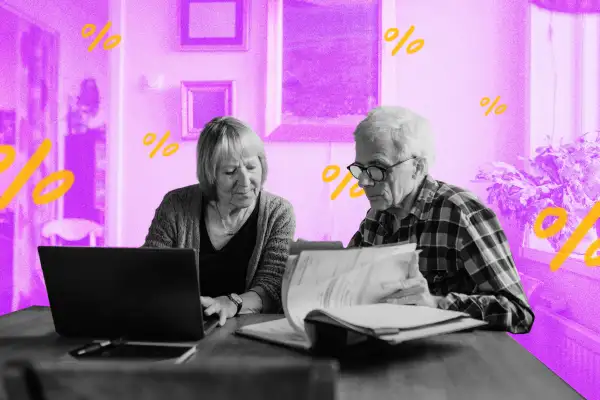 Senior couple using a laptop and looking through papers at home