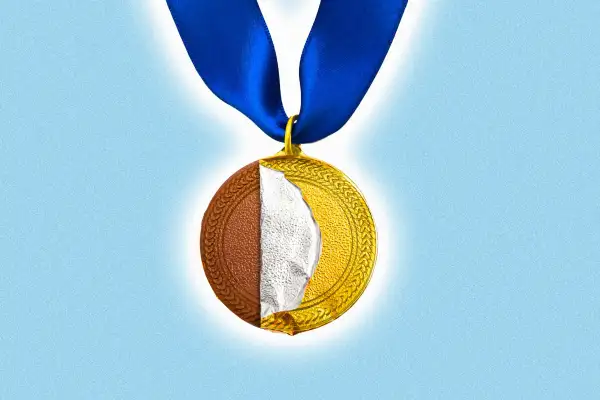 A gold medal with the foil peeled away to reveal a chocolate coin.