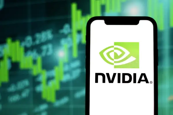 Close-up of a phone with the Nvidia logo and a stock chart in the background