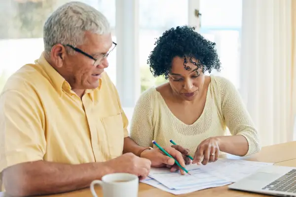 Senior man and woman looking over bills at home