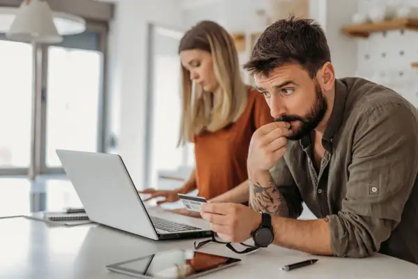 Man and woman looking over credit card bills with a concerned look