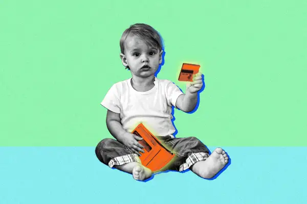 A toddler holding a wallet and credit card