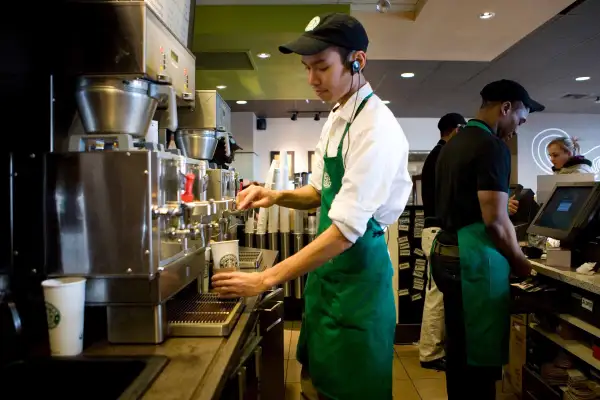 Photo of a Starbucks employee preparing a drink