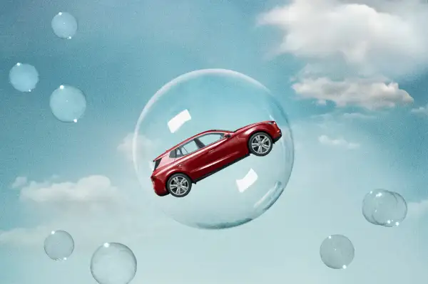 Photo collage of a car inside a bubble floating up into the sky