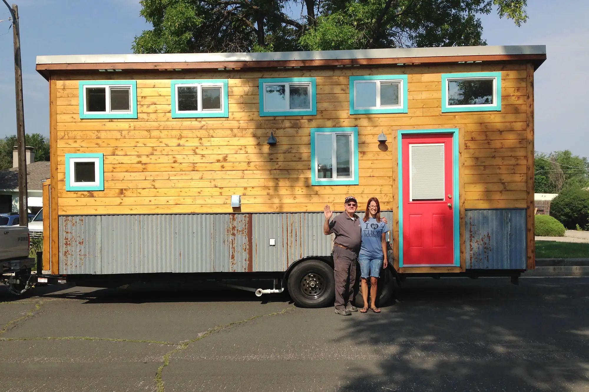 Jenny Comperda and friend standing in-front of a tiny home on wheels