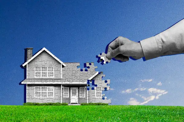 A hand placing a puzzle piece to a house shape puzzle