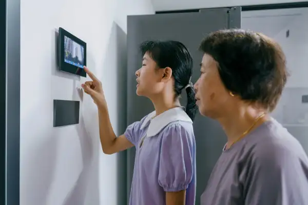 Grandma and granddaughter use a video doorbell at home