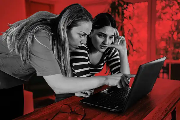 Two women looking at a computer screen with worried expressions