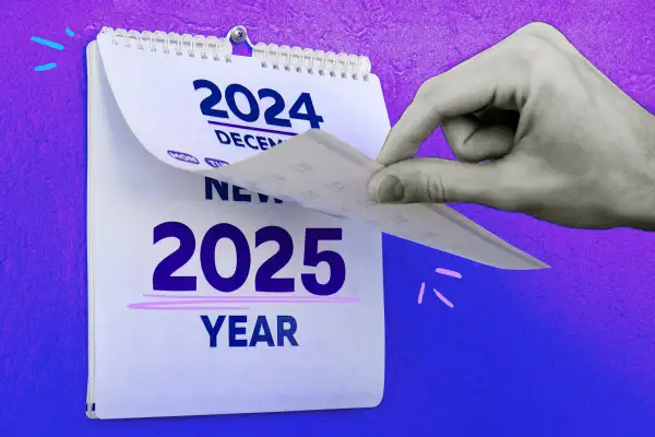 Close-up of a hand turning over a calendar page from December 2024 to January 2025