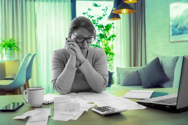 Woman looking over receipts in her home