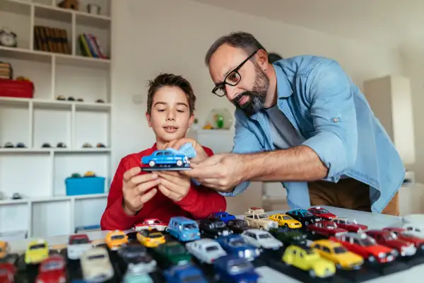 Photo of father and son with his car collection