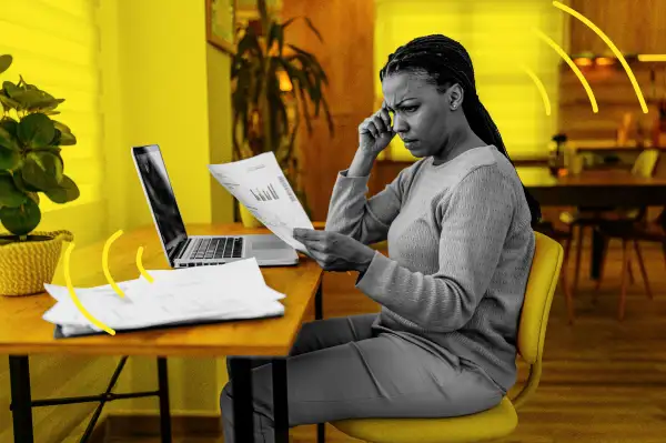 Woman with worried expression looking over paper documents