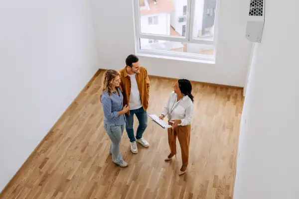 Real estate agent showing an empty apartment to a couple