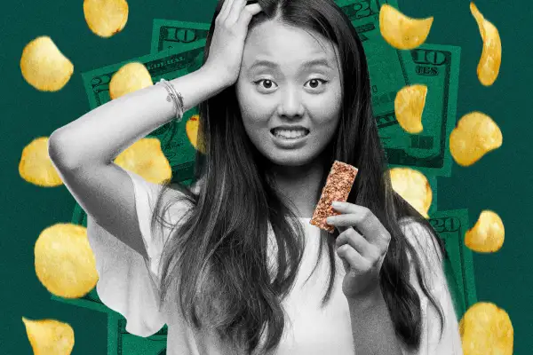 Girl with shocked face holding a granola bar, with chips and money in the background