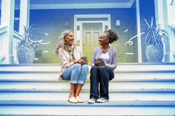 Two senior women having coffee on a porch