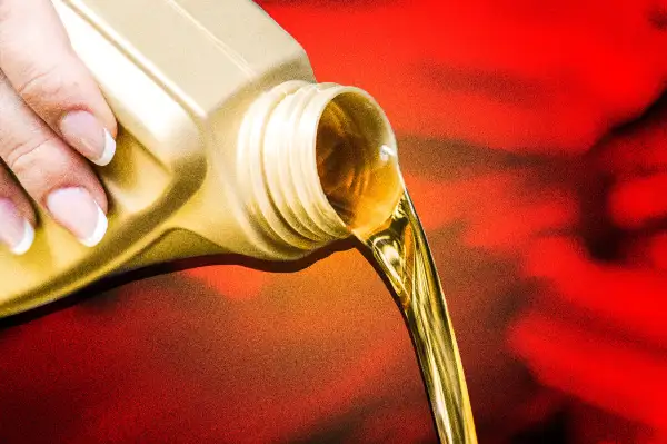 Close-up of a hand pouring out motor oil from a bottle